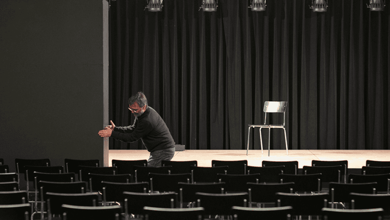 Leerer Saal mit Bühne und Stuhlreihen